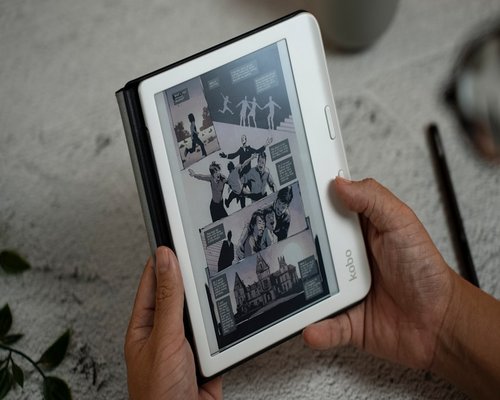 Close up of hands holding a printed book instead of a tablet